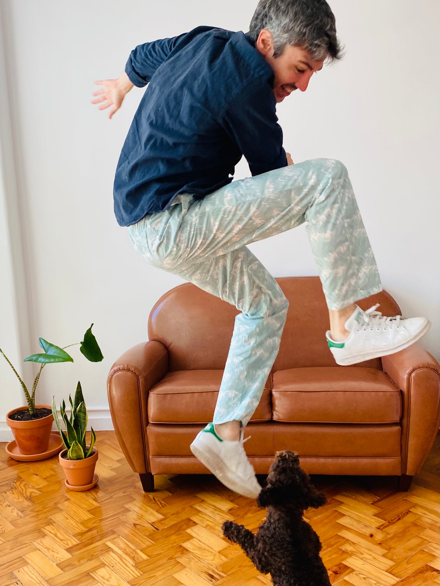 Man jumping at home in pyjamas